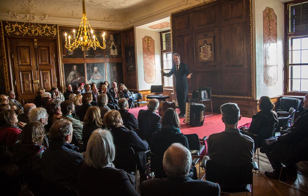 Im Fürstenzimmer des Schloss Seggau hört das Publikum gespannt der Anmoderation des Künstler zu
